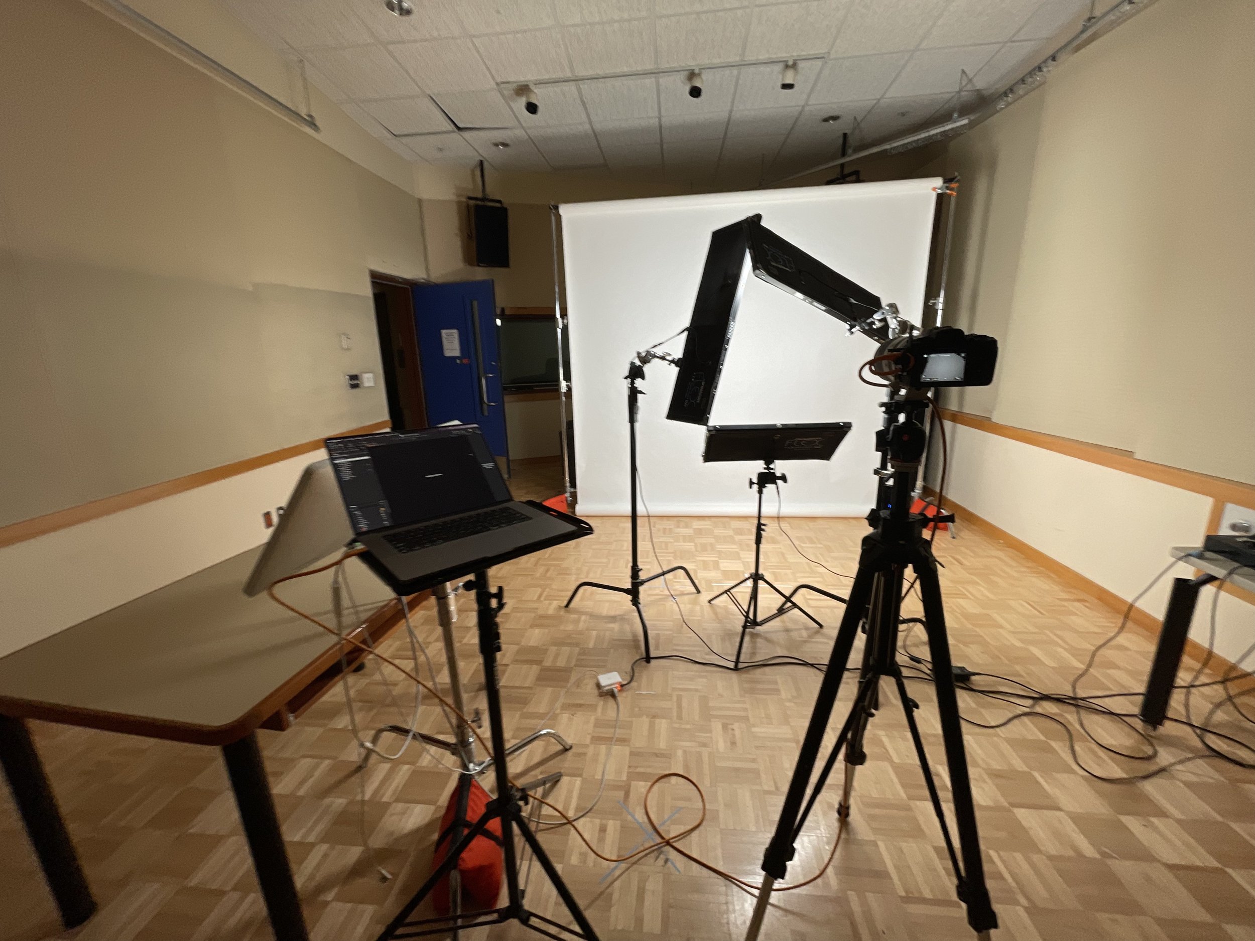 Ryan Parker’s on-location headshot setup, lights, backdrop and tethered screen, in an empty hall