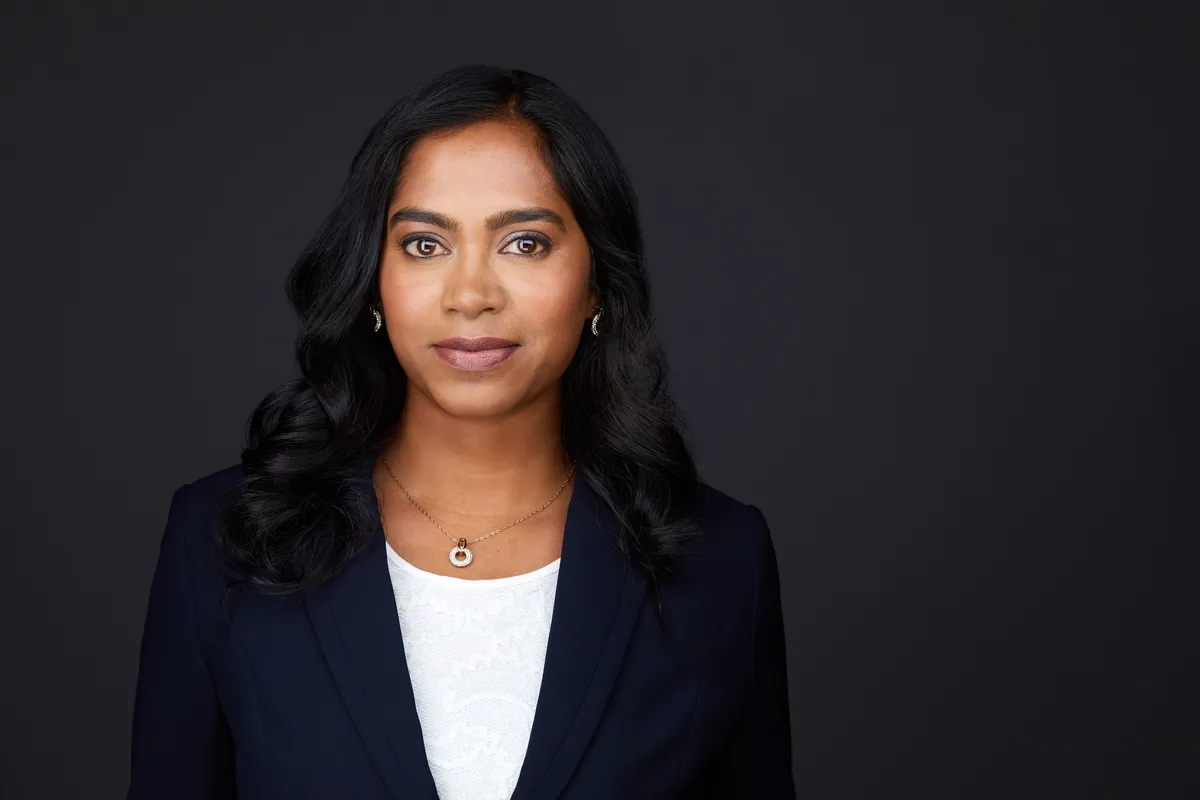 The same session, a frame kept and retouched: a navy blazer on charcoal