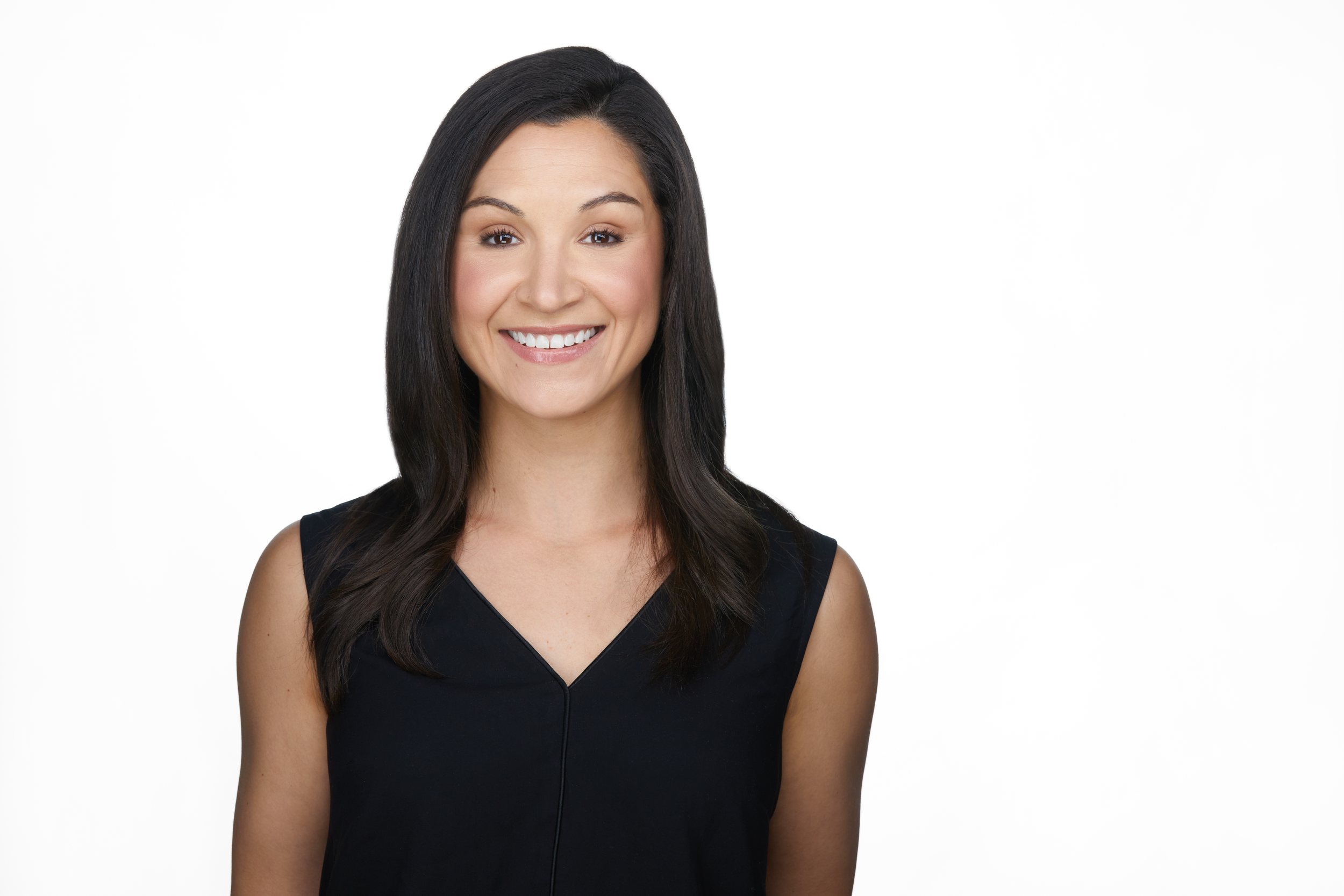 Real estate headshot: long dark hair, a black sleeveless top, on white