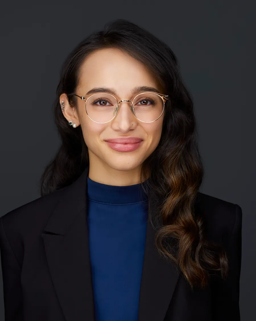 Chivers Carpenter staff headshot, Edmonton: glasses, a black blazer over blue, on charcoal