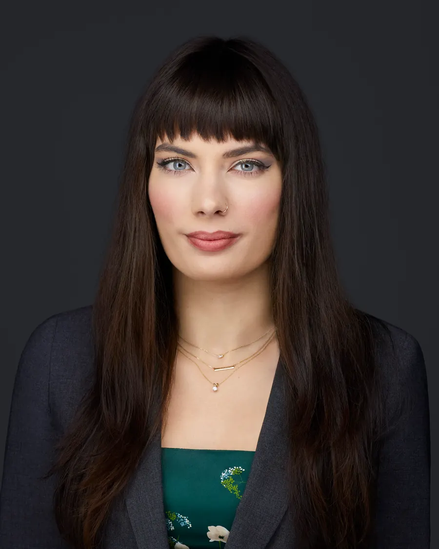 Chivers Carpenter staff headshot, Edmonton: a dark blazer over a green print, on charcoal