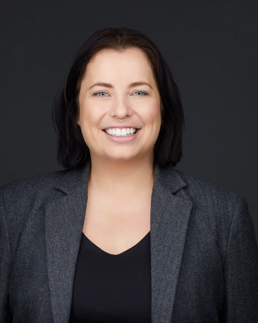 Chivers Carpenter staff headshot, Edmonton: a grey blazer over black, on charcoal