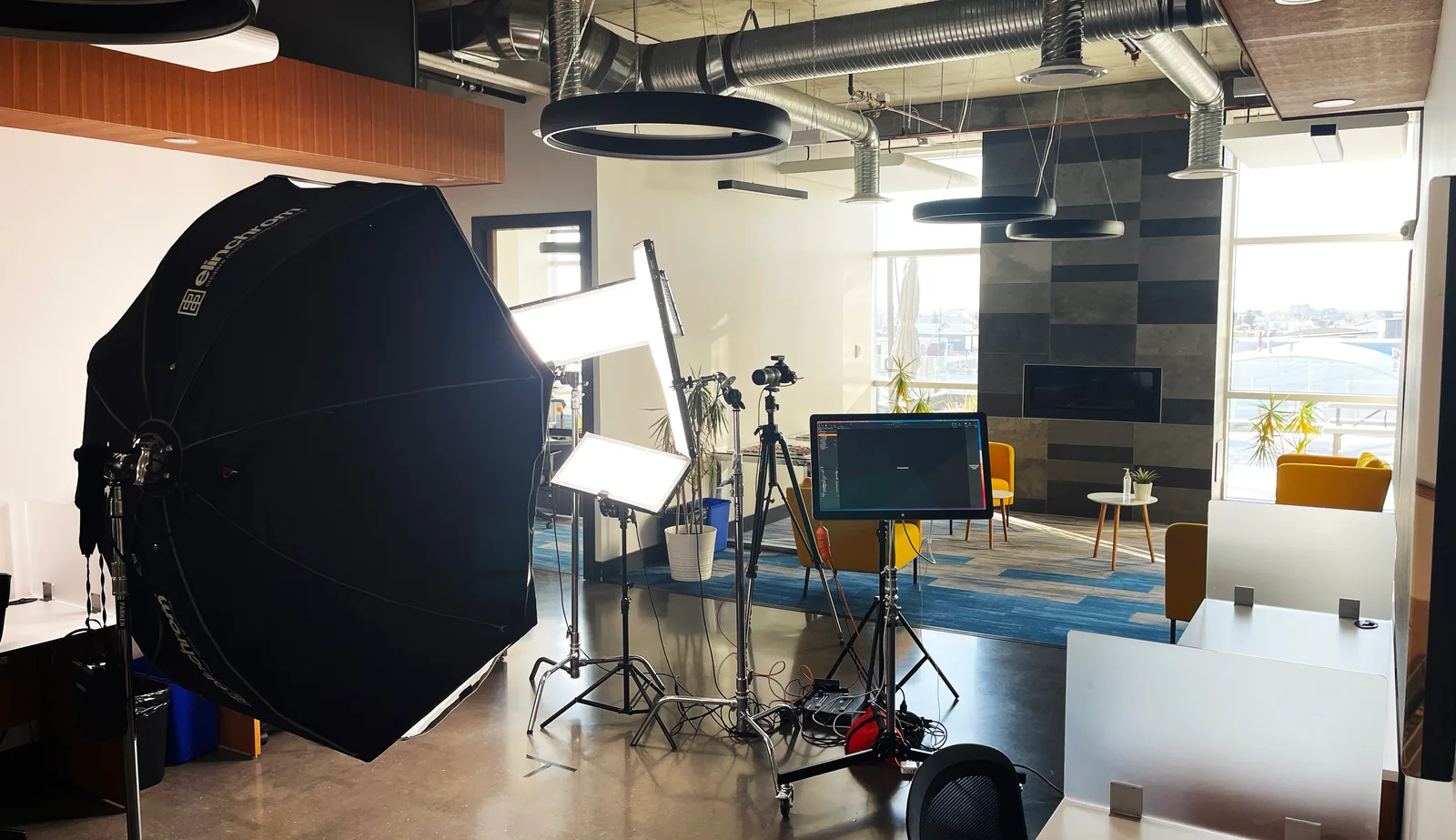A full headshot setup, with octabox, panels, camera and monitor, standing in the middle of a client’s open-plan office in Edmonton